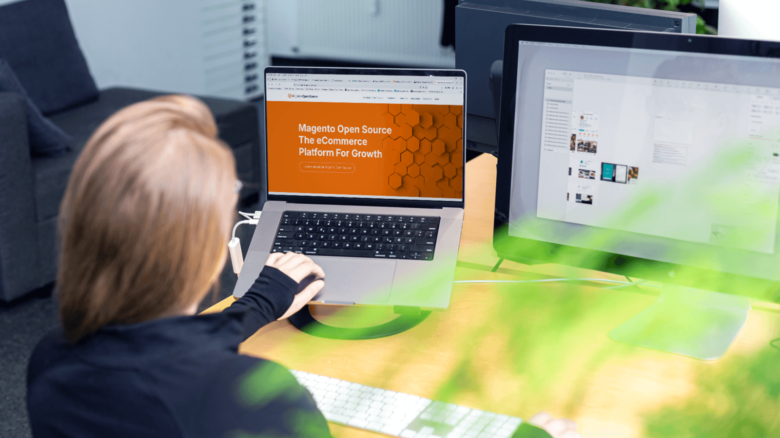 Mitarbeiterin startet auf zwei Monitoren mit dem Magento Security Check